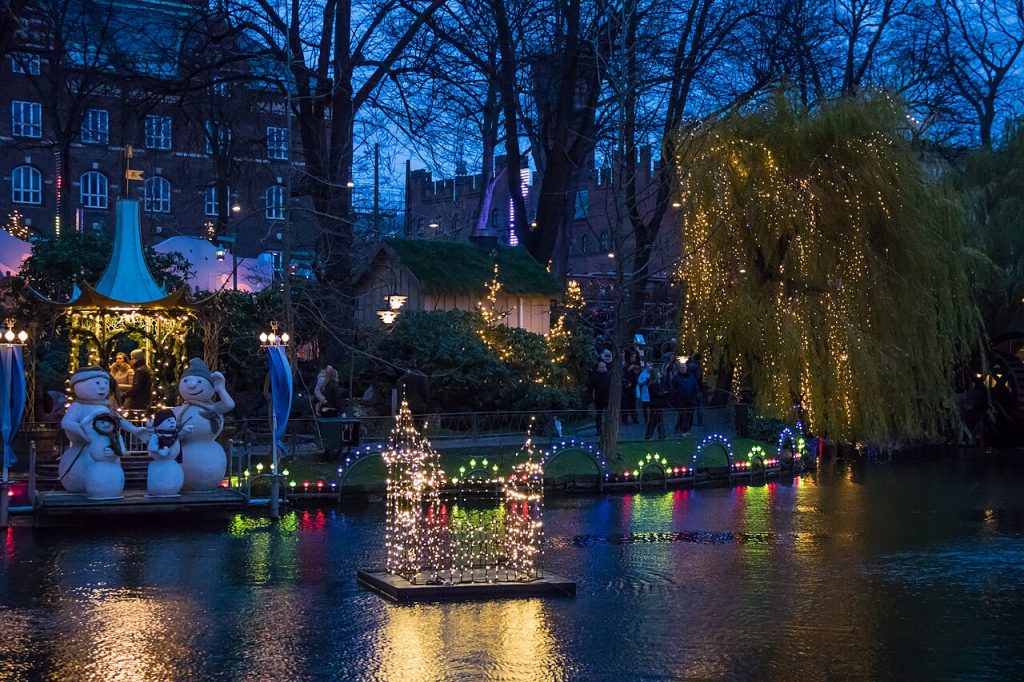 Tivoli pyntet til jul med lys over søen