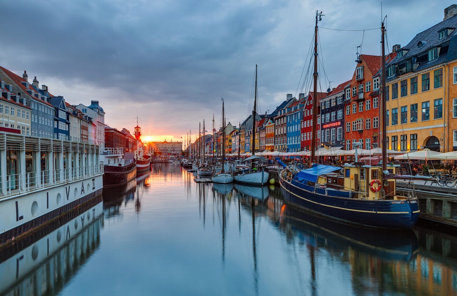 Nyhavn i solnedgang med skibe og farvede huse